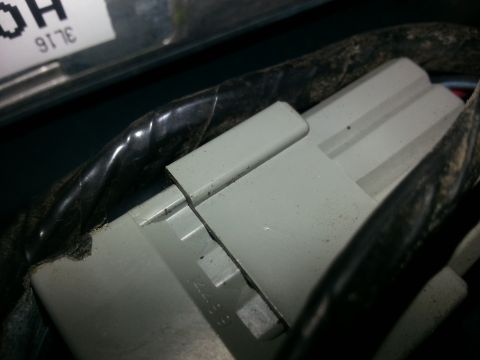 1994 Ford Bronco - Close-up of a gray electrical connector and black wiring, with some text visible in the background.