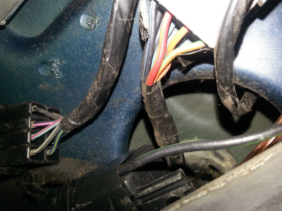 Close-up of a vehicle's wiring harness with multiple colored wires and connectors