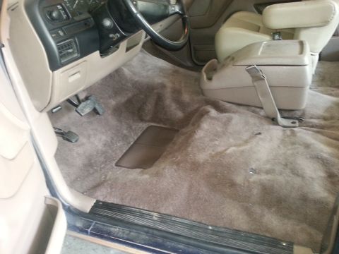 1994 Ford Bronco - The interior of a 1994 Ford Bronco shows worn brown carpet and beige seats.