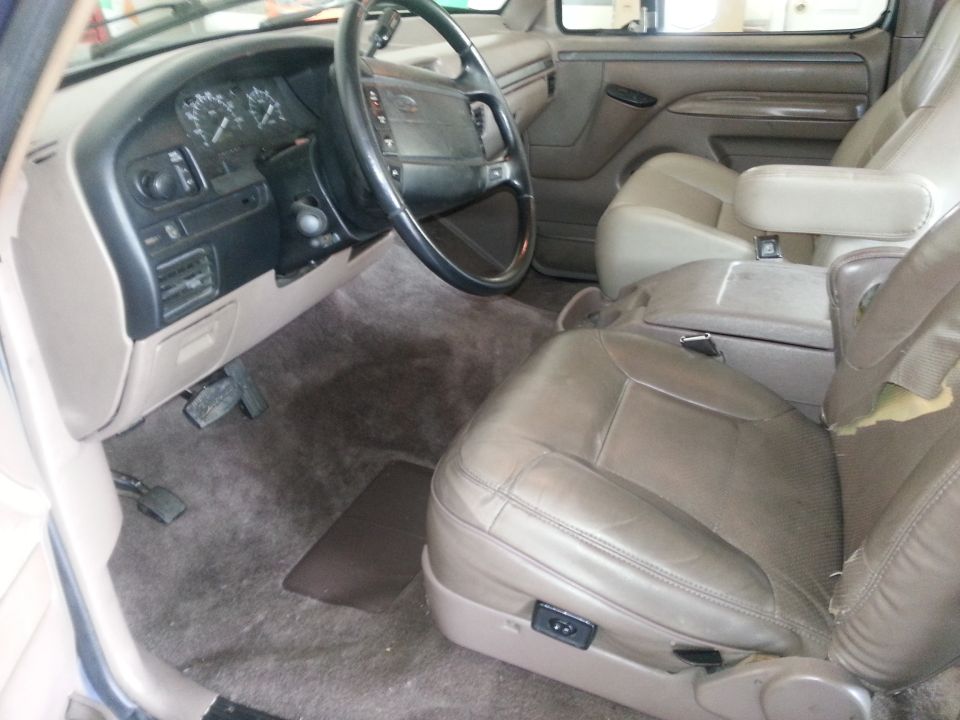 Interior of a 1994 Ford Bronco showing dashboard, steering wheel, and seats