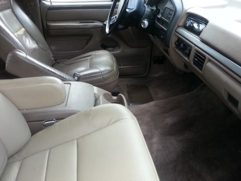 1994 Ford Bronco - Interior of a 1992 Ford Bronco, tan leather seats and a dark dashboard.
