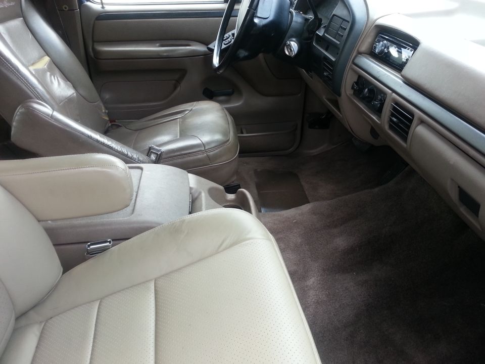 Interior view of a 1992 Ford Bronco showing front seats, dashboard, and center console