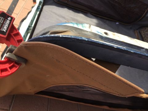 1995 Ford Bronco - A close-up view of a vehicle's soft top fabric and trim, held by a clamp.
