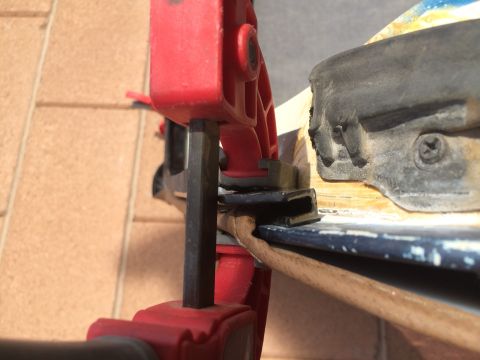 1995 Ford Bronco - A close-up shot shows a black rubber seal being held in place by a clamp against a wooden surface.