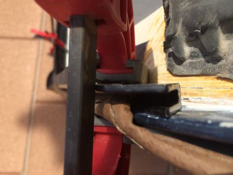 1995 Ford Bronco - A close-up shot shows a black rubber seal being secured by a clamp, with a wooden surface visible.