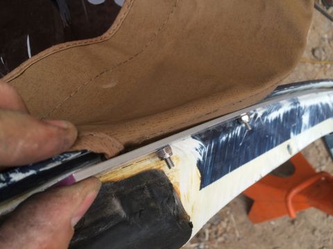 1995 Ford Bronco - Detail of the soft top attachment mechanism, showing screws and a metal strip.