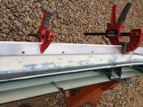 1995 Ford Bronco - A vehicle body panel is clamped down, showing signs of wear and repair work.