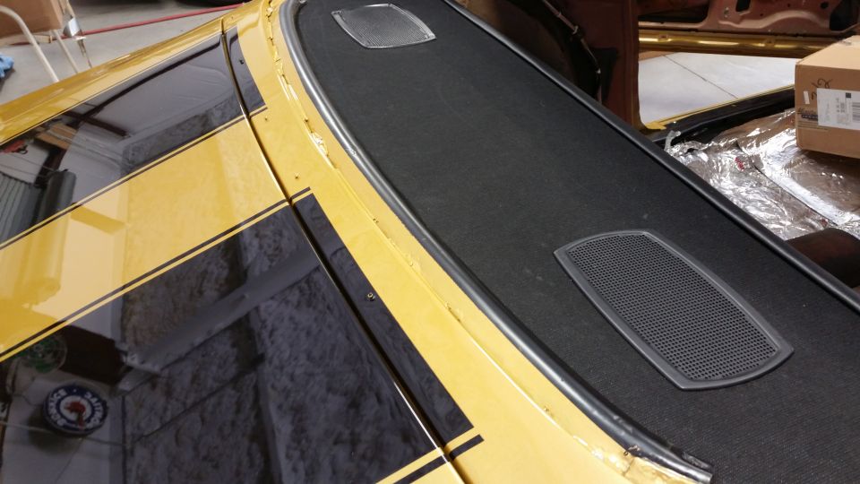 1970 Chevrolet Camaro interior showing dashboard with speaker grilles and yellow exterior paint with black stripes