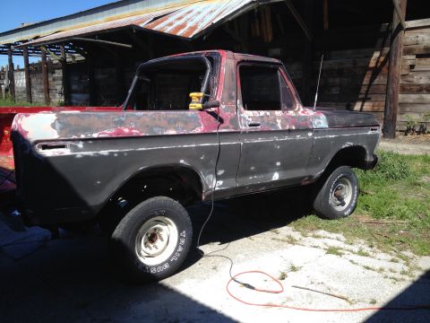 1978 Ford Bronco - This pickup truck is in a state of repair, with primer and rust showing on its body panels.