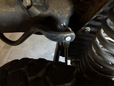 1995 Ford Bronco - Undercarriage view of a vehicle's suspension, a coil spring and control arm assembly.