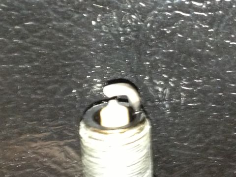 1961 International Scout 800 - A close-up view of a single spark plug, showing its electrode and threaded base.