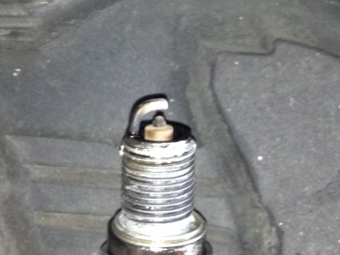 1961 International Scout 800 - A close-up view of a spark plug, showing deposits on its threaded portion.