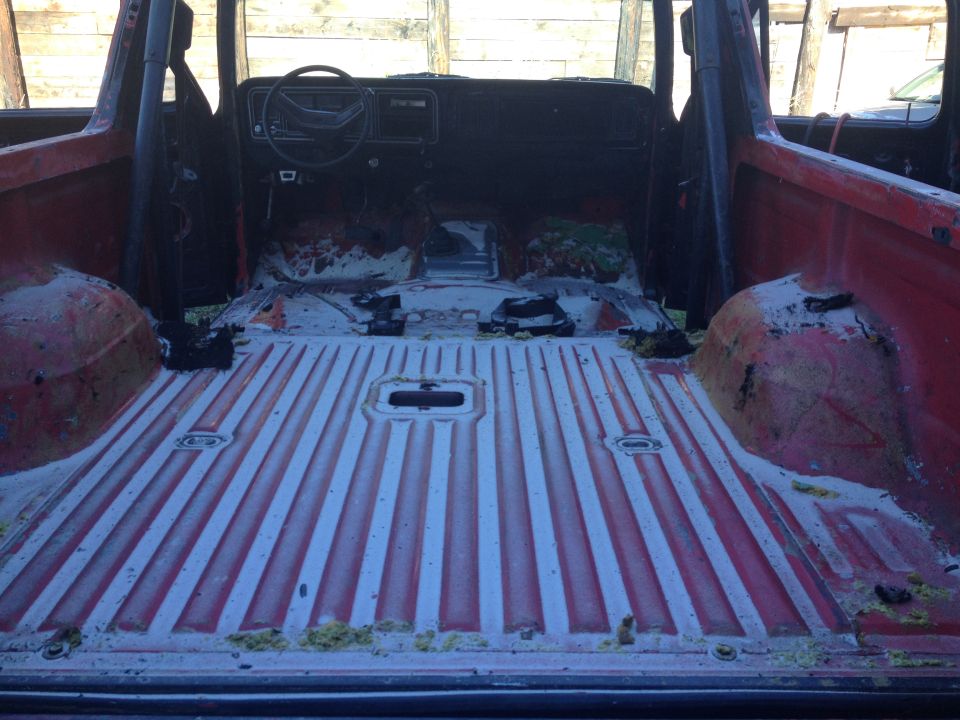 Red SUV interior, stripped down with exposed metal floor and dashboard