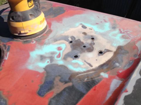 1978 Ford Bronco - Sanding down a vehicle's body panel to prepare for repair and repainting.