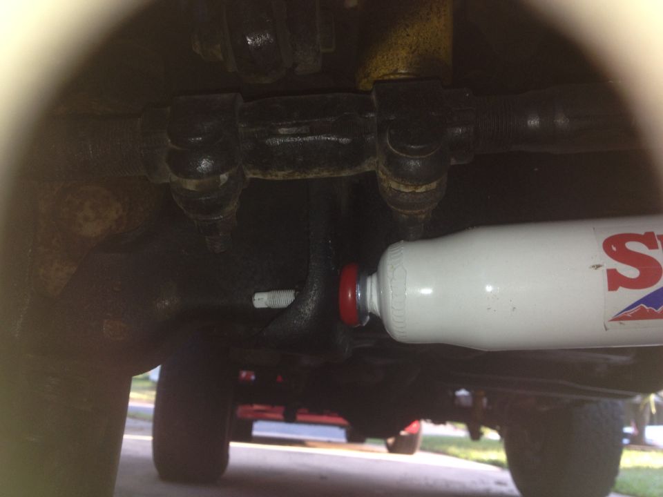 Undercarriage view of a white shock absorber with red and blue lettering