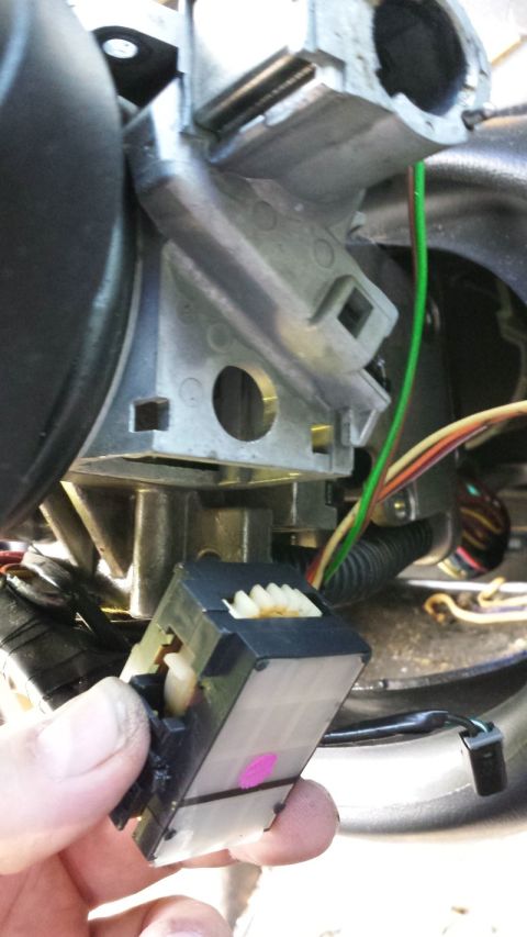 2000 GMC Jimmy - Close-up of a vehicle's ignition switch actuator being held by a hand, with wiring visible.