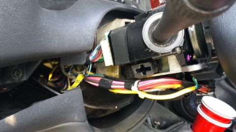 2000 GMC Jimmy - Exposed wiring and ignition switch assembly in a vehicle's steering column.