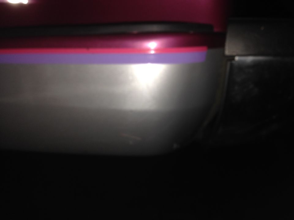 Close-up of a car's door trim with purple and pink stripes