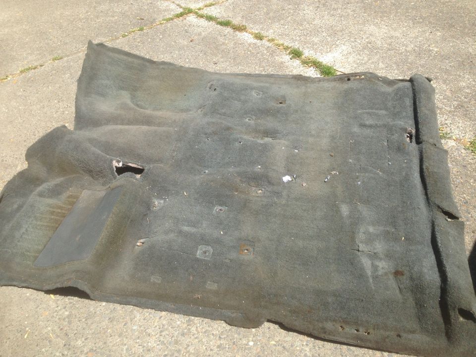 Used vehicle carpet laid out on concrete