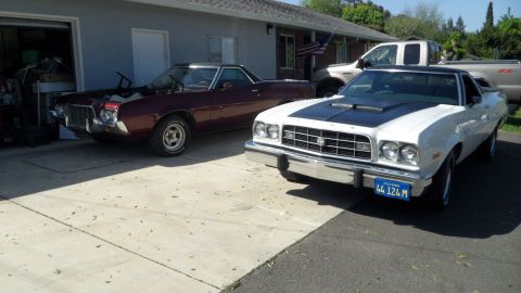 1972 Ford Ranchero - Two Ford Rancheros are parked in a driveway, one white and one maroon, with a pickup truck behind them.