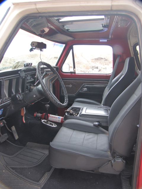 1978 Ford Bronco - Interior view of a 1978 Ford Bronco, bucket seats, a sunroof, and a fire extinguisher.