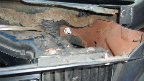 1972 Ford Ranchero - Close-up view of a corroded metal bracket and aged insulation within a vehicle's interior.