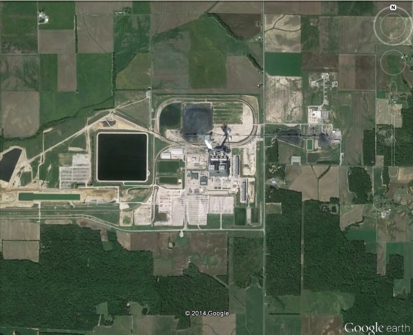Aerial view of a large industrial facility with surrounding agricultural fields and water reservoirs