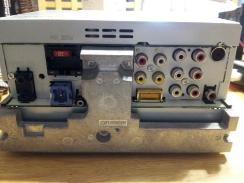 2002 Chrysler 300M - The rear panel of a car stereo unit displays multiple input and output ports, along with a fuse holder.