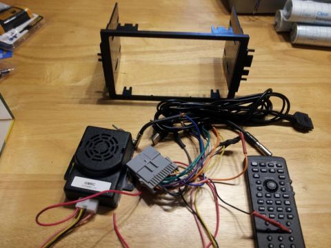 2002 Chrysler 300M - Various components for installing a car stereo system are laid out on a table.