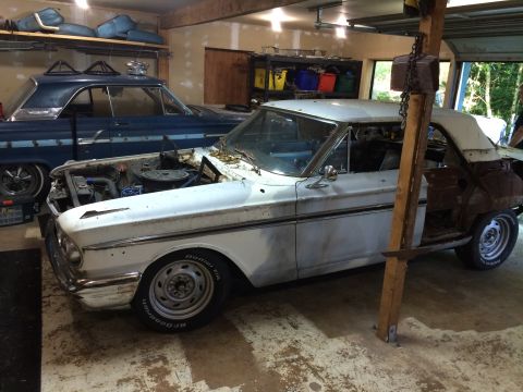 1964 Ford Fairlane - A white 1964 Ford Fairlane convertible is seen in a garage with its hood open, in a state of restoration, with another blue car behind it.