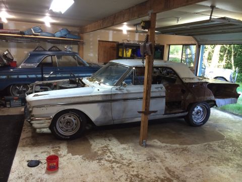 1964 Ford Fairlane - Two classic Ford Fairlanes in a garage, one in a state of disassembly and repair.
