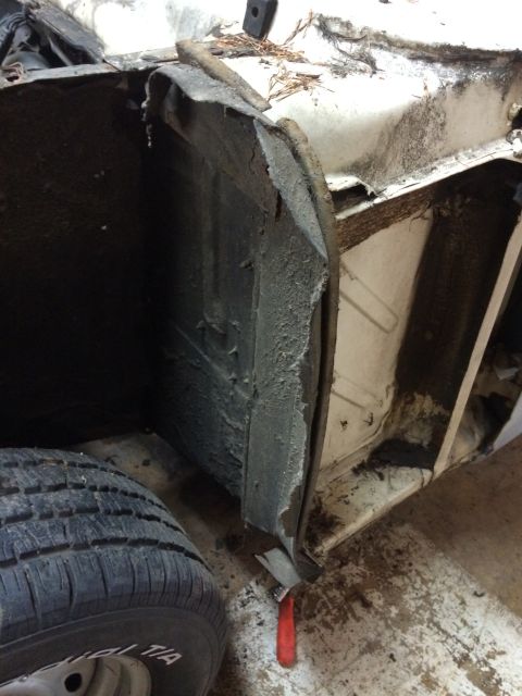 1964 Ford Fairlane - Close-up view of the interior wheel well and chassis of a vehicle undergoing deconstruction.