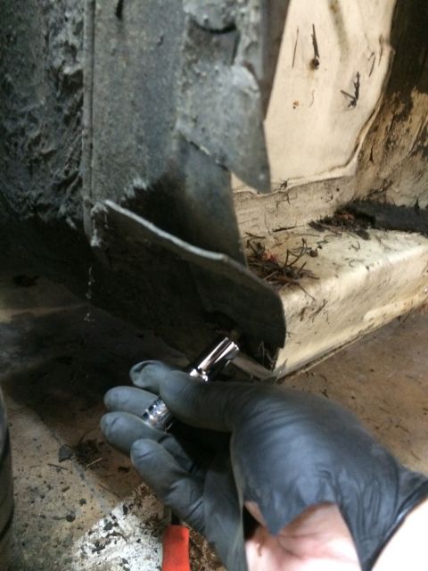 1964 Ford Fairlane - Working on a car's frame with a socket wrench.