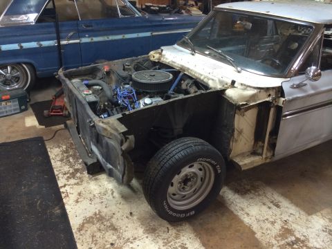 1964 Ford Fairlane - A 1964 Ford Fairlane is shown in a workshop with its front end disassembled, revealing the engine.