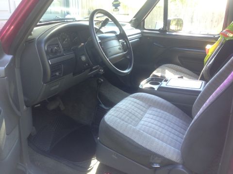 1992 Ford F-150 - Interior of a 1990s Ford pickup with gray cloth seats, center console, and a dashboard viewed from the passenger side.