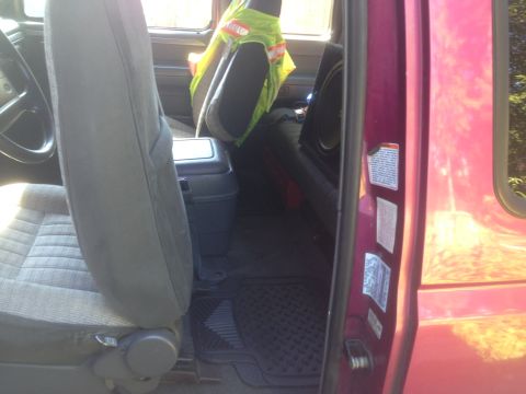 1992 Ford F-150 - The interior of a 1992 Ford F-150 reveals gray cloth seats and a black center console, with a door jamb sticker visible.