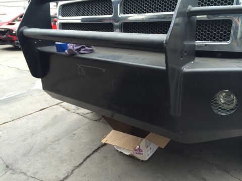 1997 Dodge 3500 - Close-up of a heavy-duty front bumper and brush guard, with a red vehicle in the background.