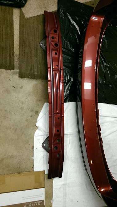 2015 Subaru Forester - Car body parts, including a curved panel and a straight reinforcement beam, laid out on the floor.