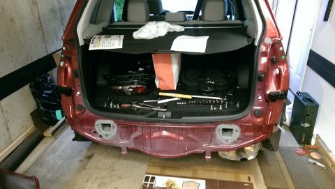 2015 Subaru Forester - Tools are laid out in the cargo area of a red Subaru Forester during rear bumper removal.