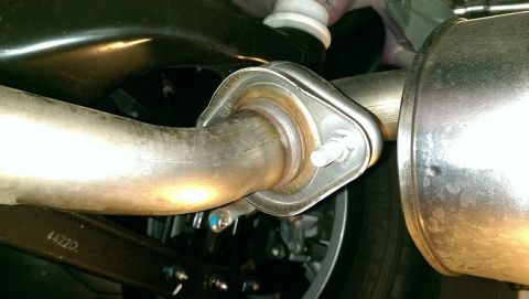 2015 Subaru Forester - Close-up view of a vehicle's exhaust system connection, showing a flange and gasket.