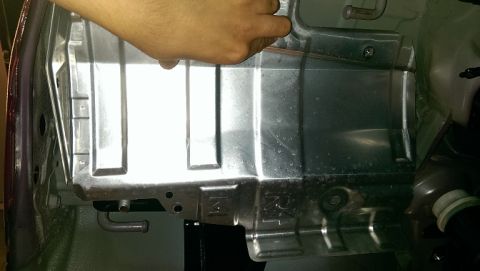 2015 Subaru Forester - A close-up view of a vehicle's undercarriage, focusing on a metal component. Text is visible on the component.