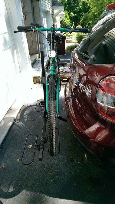 2015 Subaru Forester - Bicycle secured to a hitch rack on the back of a vehicle.