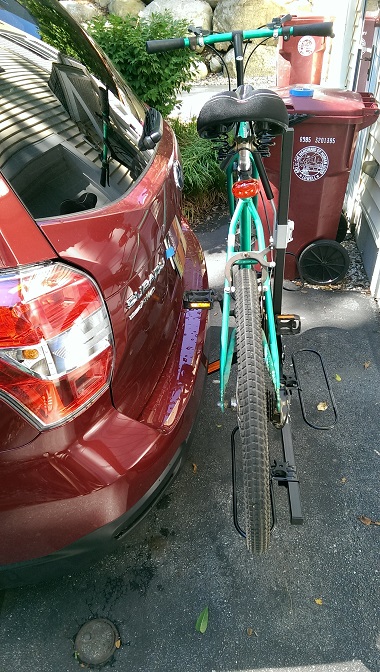 2015 Subaru Forester - A teal bicycle is attached to the hitch of a dark red Subaru Forester.