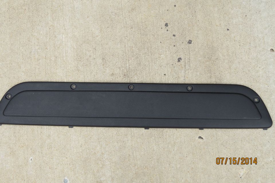 black plastic trim piece with visible screw holes and a date stamp at the bottom right