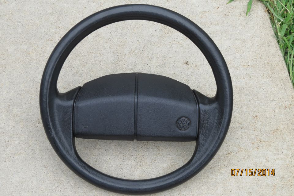 Volkswagen steering wheel with a circular VW logo on the center hub