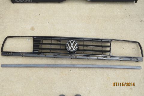 1985 Volkswagen Jetta - A Volkswagen grille, likely from a 1985 model, is displayed on a concrete surface.