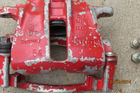 1985 Volkswagen Jetta - A red brake caliper with "VW" logo and "Germany" text is shown, with visible wear and tear.