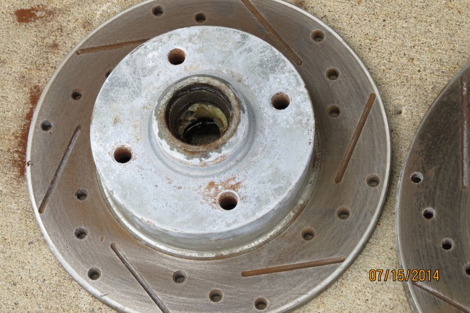 Slotted brake rotor with visible rust and wear