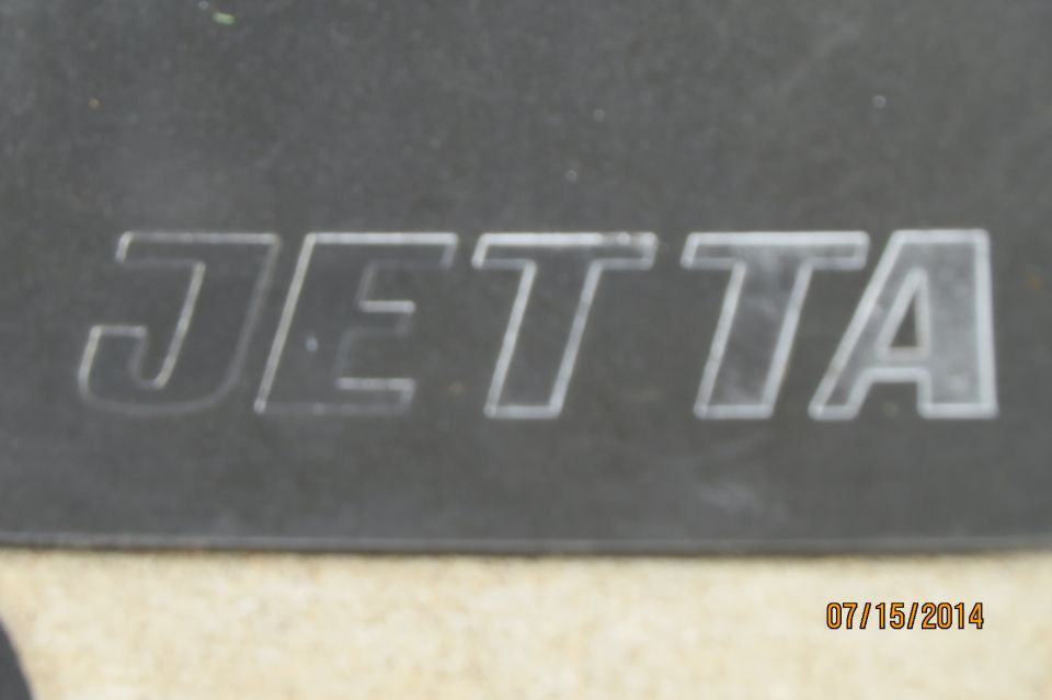 Embossed Jetta emblem on dark background