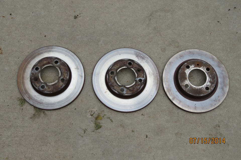 Three brake rotors on concrete. Date stamp reads 07/15/2014